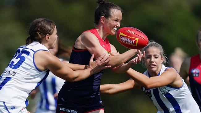 Daisy Pearce handballs as she is set upon by two North opponents. Picture: AAP<br/>