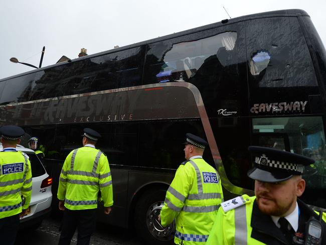 The bus carrying the Manchester United team is escorted by police after having a window smashed.