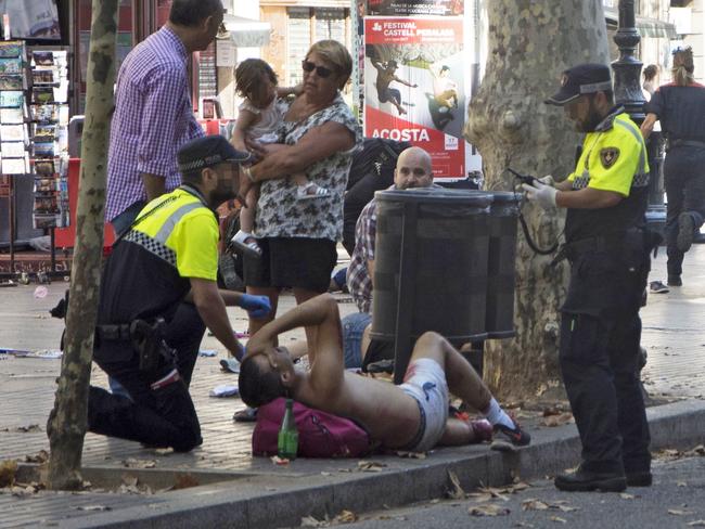 Police officers tend to injured people after a van crashed into pedestrians in Las Ramblas, Barcelona. Picture: EPA/David Armengou