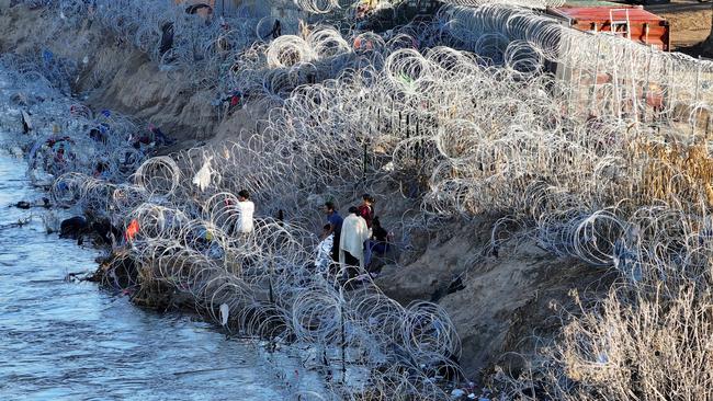 A group of migrants stand on the edge of Rio Grande in Eagle Pass, Texas, at the weekend. Picture: Reuters