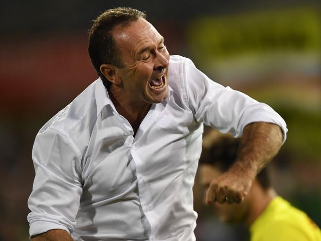 Raiders coach Ricky Stuart celebrates a try against the Bulldogs on the sideline.