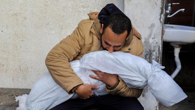 A Palestinian man hugs the body of his child. Picture: Ahmad Hasaballah