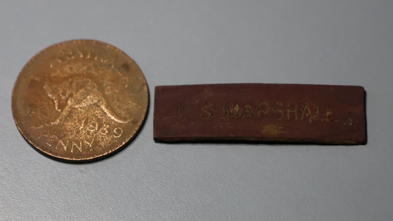 Items retrieved from the site of a 1942 Qantas plane crash including the name tag of co-pilot Lindsay Stuart Marshall. Picture: Fred Wimmer