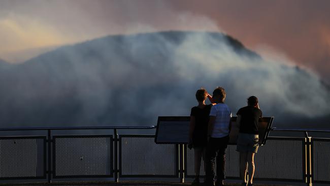 People watch as smoke from the Green Wattle Creek fire from Echo Point lookout on December 6. Picture: AAP/Steven Saphore