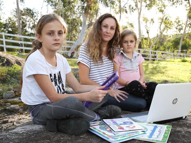 Natalie Koomen from Middle Dural says her kids Fleur, 9, and Maeve, 6, have to take their computers in to the paddock to get NBN reception to do their home-schooling during the COVID-19 virus pandemic. Picture: David Swift