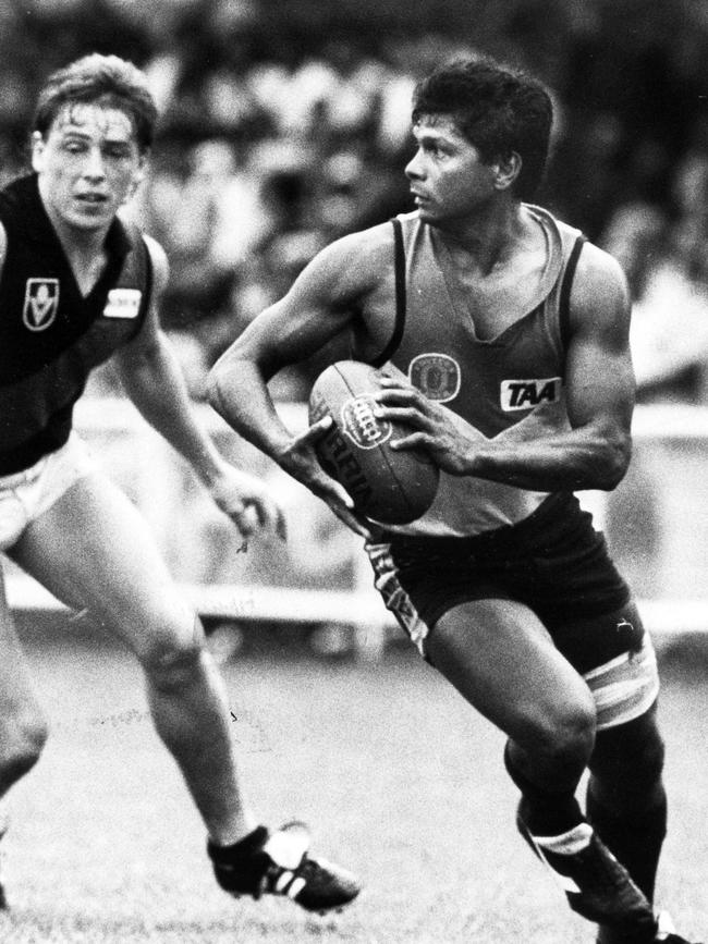 His dad, Maurice Rioli Sr, gets away from Essendon’s Mark “Bomber” Thompson in a game in Darwin in 1988.