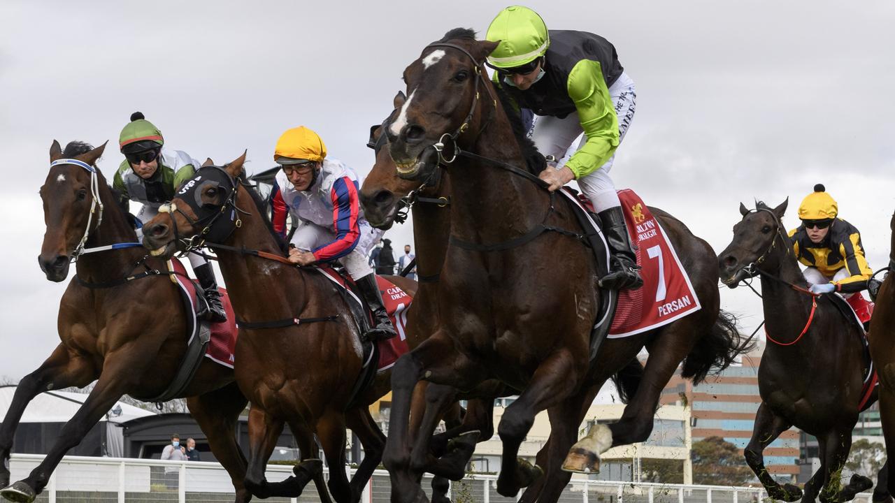 Brett Prebble riding Incentivise (L) in to the first turn before winning Race 9, the Carlton Draught Caulfield Cup.