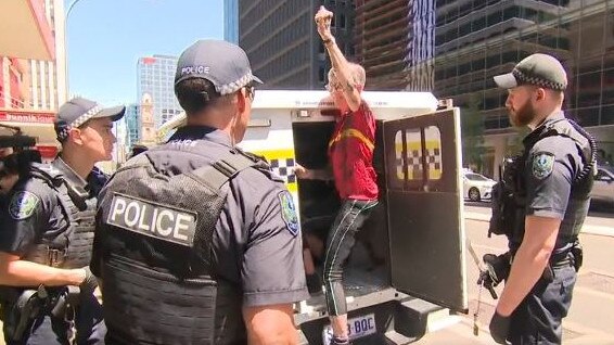 An Extinction Rebellion protester is arrested outside Santos. Picture: 9 News