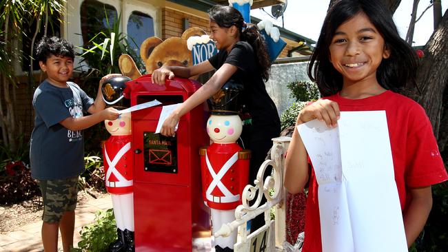 Amisha Nagaretman shows off her letter to Santa while her siblings Michael and Nishelle post the man in red via the Emu Plains letterbox. Picture: Toby Zerna