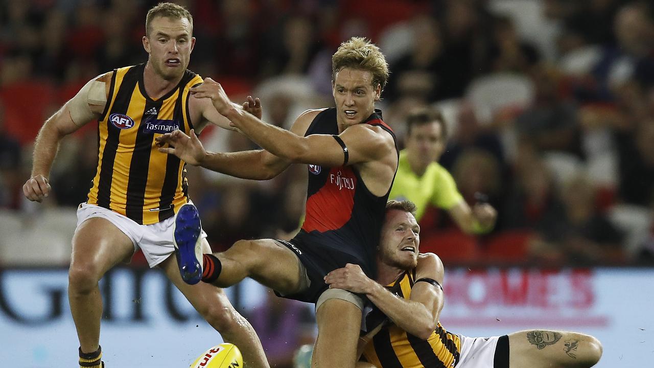 Darcy Parish of the Bombers is tackled by Blake Hardwick of the Hawks