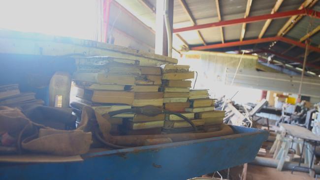 Richie Britten's book collection stacked on an old boat. Picture: Peter Carruthers