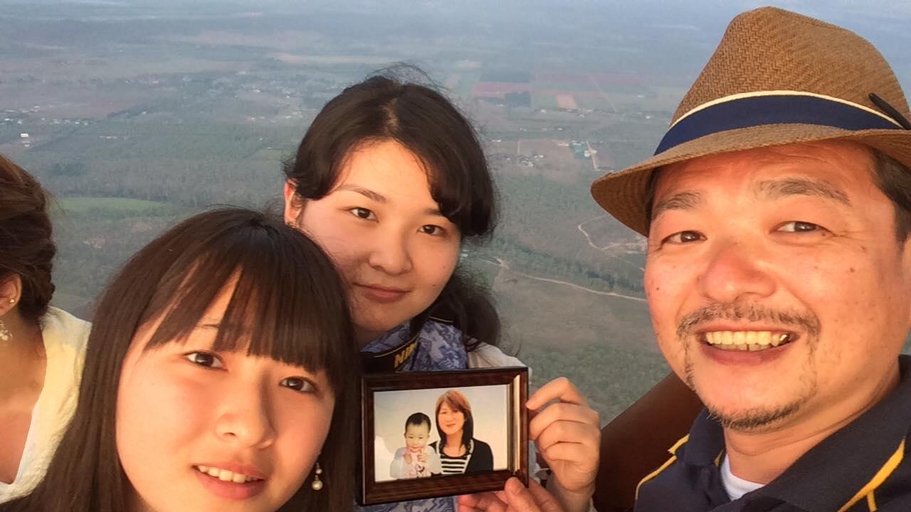 Kamaishi Seawaves general manager Toshio Hamato is pictured with his two surviving daughters, holding a photo of his deceased wife and daughter.
