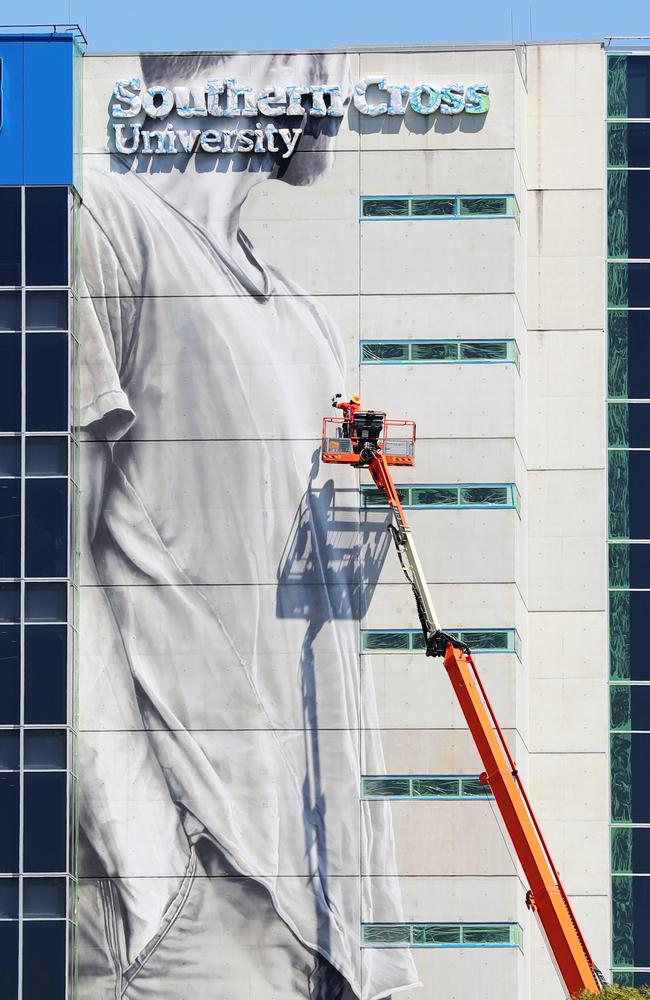 Mr van Helten paints the massive mural. Picture: NIGEL HALLETT