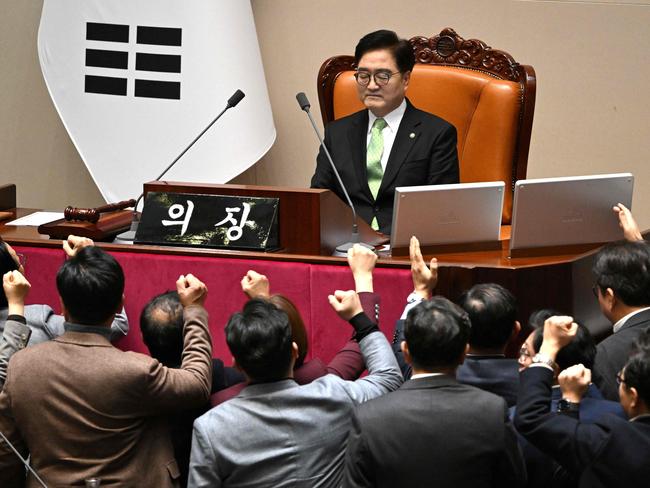 TOPSHOT - South Korea's ruling People Power Party lawmakers (bottom) argue to National Assembly Speaker Woo Won-shik (C top) during the plenary session for the impeachment vote of acting president Han Duck-soo at the National Assembly in Seoul on December 27, 2024. (Photo by JUNG YEON-JE / AFP)