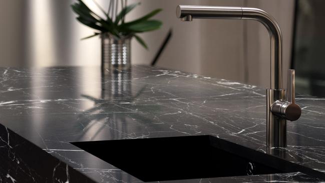 Dark solid granite sink with modern stainless steel tap.