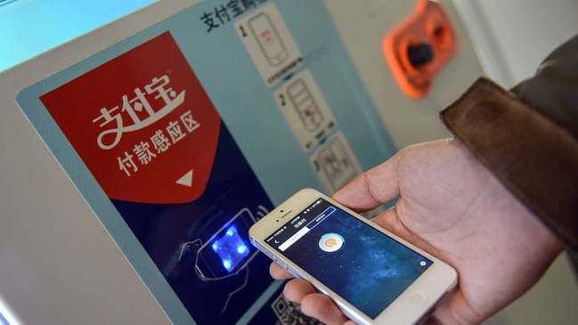 An Alipay employee shows how to send money with a smartphone. Popular online payment services have made many Chinese consumers comfortable sending money from their screens and attractive to companies that pitch loosely regulated, often risky investments. PHOTO: HAN CHUANHAO/XINHUA/ZUMA PRESS