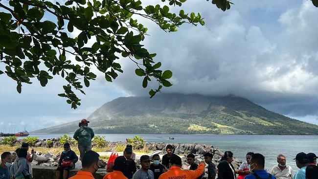 People in Sitaro, North Sulawesi looking at the Mount Ruang volcano, as it spews smoke. Picture: AFP