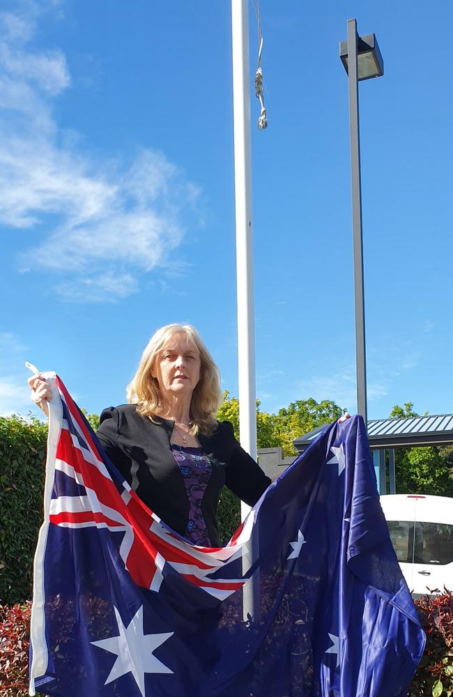 Brisbane City Councillor Angela Owen (Calamvale ward) with a new flag to replace the stolen one.