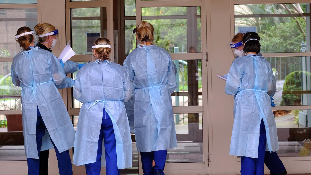 Health workers arrive to check on tenants of the townhouse complex at Wells Street in Southbank. Picture: NCA NewsWire / Luis Ascui