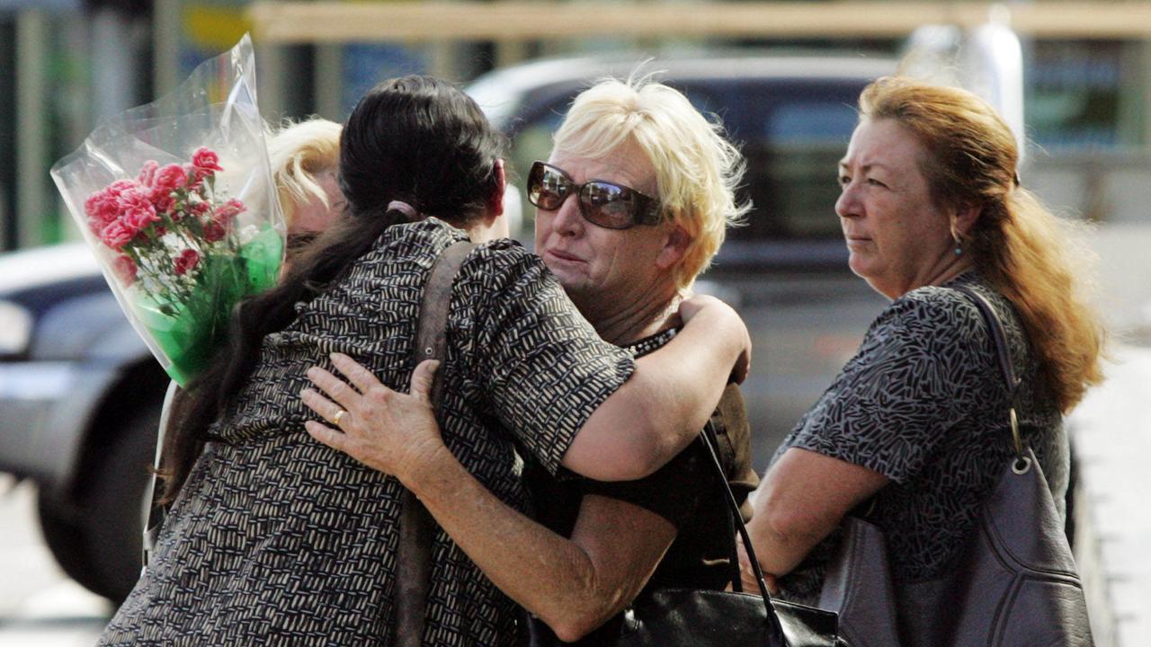 Women comfort each another outside Union St mixed business store in Newcastle where owner Frank Newbery, 87, was found murdered.