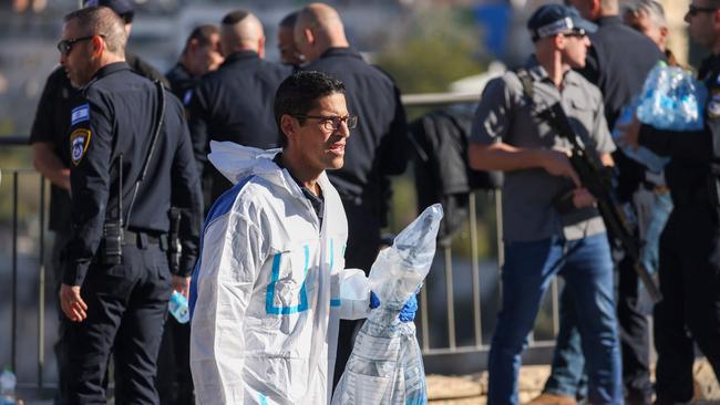 A member of an Israeli forensics team carries a weapon reportedly used at the scene of a shooting. Picture: Ronaldo Schemidt / AFP