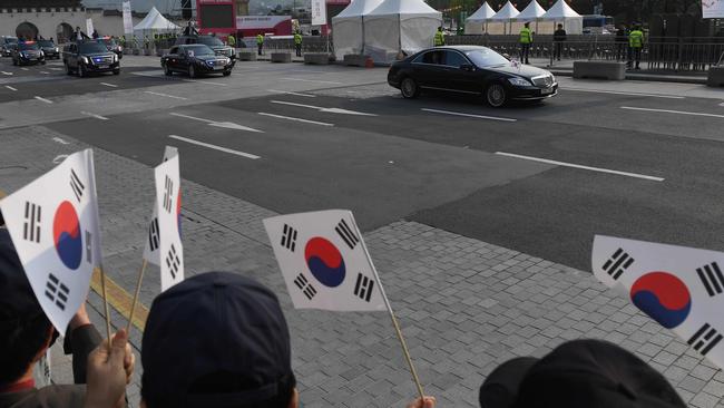 Korean military veterans watch as the motorcade carrying South Korean President Moon Jae-in passes through Seoul. Picture: AFP.