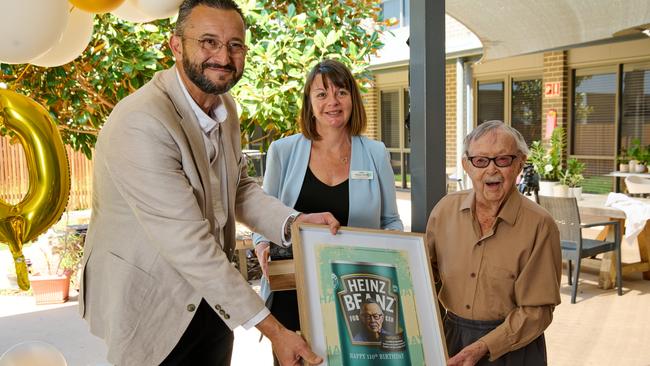 Whiddon CEO Chris Mamarelis, Deputy CEO Alyson Jarrett and Ken Weeks with his framed special issue Baked Beans dedicated to his love of baked beans.