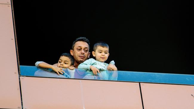 A distraught man holds his children at a hotel window at Peppers medi-hotel, Adelaide, on November 17. Picture: The Australian, Morgan Sette