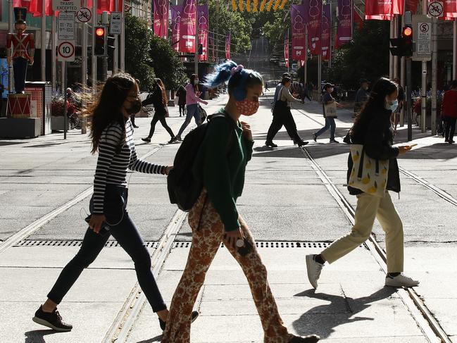 MELBOURNE, AUSTRALIA - DECEMBER 10: Some people are seen wearing face masks on Bourke Street on December 10, 2020 in Melbourne, Australia. Victoria has recorded its 41st day without any new COVID-19 cases, with no one diagnosed with coronavirus since 30 October in Victoria. Mask-wearing is now only mandatory in indoor shopping centres and public transport, including rideshares and taxis, but relaxed in other settings. Victorians must still carry a mask with them at all times and wear it when a physical distance of 1.5 metres cannot be maintained, but mask use is encouraged, but not mandatory, in other situations. Cafes, restaurants and pubs can double their patron numbers to a maximum of one person per 2 sq m and nightclubs can reopen from midnight. People are able to have up to 30 visitors at home, while outdoor gatherings can now have up to 100 people. (Photo by Daniel Pockett/Getty Images)