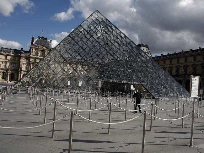 A man walks near the entrance of the Louvre Museum. Picture: AP