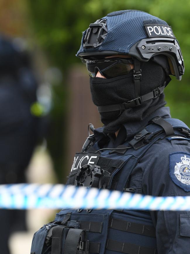 An officer stands guard outside of a property in Melbourne during raids following the Bourke Street attack. Picture: AAP