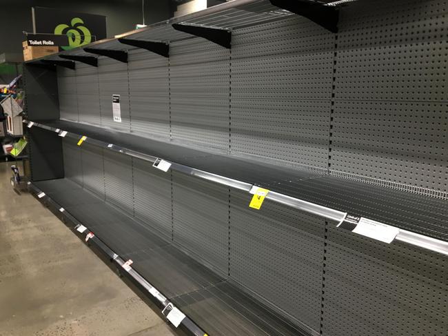 Empty toilet paper shelves in a Woolworths as lockdown kicks in. Picture: AAP