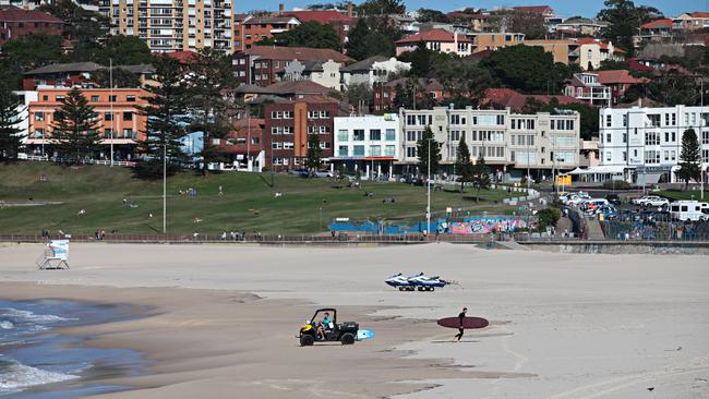 A lone surfer ignores closed beach signs to go for a surf at Bondi Beach on Sunday.