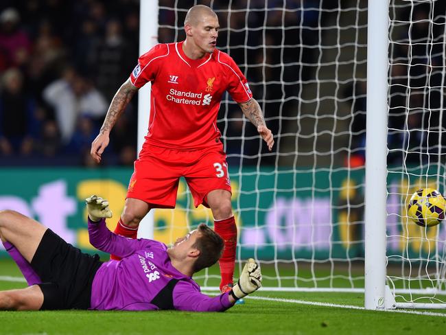 Martin Skrtel of Liverpool looks on as Simon Mignolet scores an own goal.