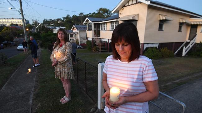 People stand outside their homes at dawn to commemorate Anzac Day in Brisbane. Picture: Dan Peled