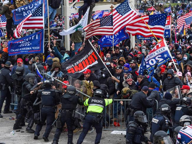 In this file photo taken on January 06, 2021, Trump supporters battle with police and security forces as they storm the US Capitol building in Washington, DC. - President Joe Biden slammed his predecessor Donald Trump Monday in a prerecorded video address to The National Organization of Black Law Enforcement Executives (NOBLE) for watching his supporters riot for hours on January 6 while police at the US Capitol suffered through a "medieval hell." (Photo by ROBERTO SCHMIDT / AFP)