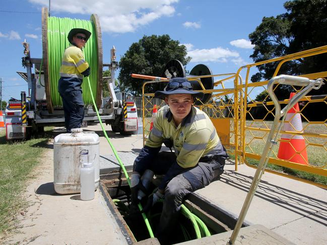 Workers laying/hauling fibre NBN cable along Dohle's Rocks Rd. Ryan Wyatt and Dylan Vincent feed the cable through the manhole.Picture : Chris Higgins