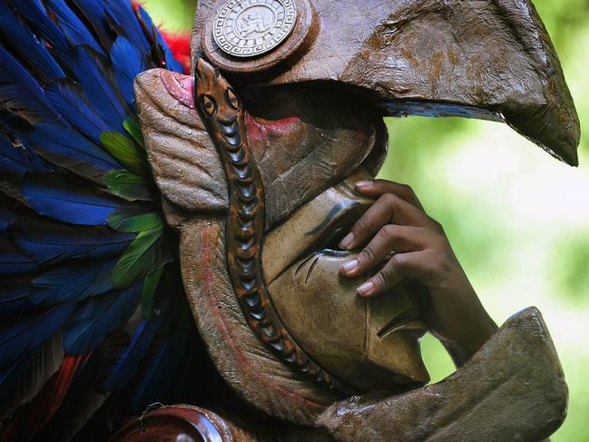 A member of a folk group performs wearing a Maya mask in Tikal archaeological site in Peten departament 560 km north of Guatemala city on December 20, 2012. Ceremonies will be held here to celebrate the end of the Mayan cycle known as Bak'tun 13 and the start of the new Maya Era on December 21. AFP PHOTO/Hector RETAMAL