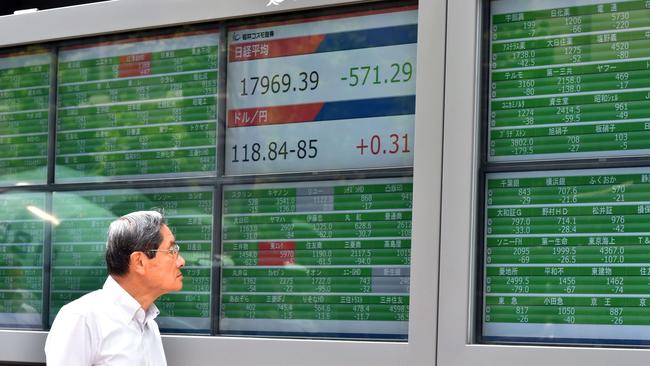 Tracking Tokyo ... An investor watches a share prices board in Tokyo on Tuesday. Picture: AFP