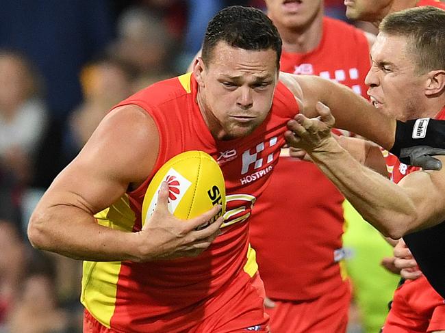 Steven May of the Suns (left) and Tom McDonald of the Demons compete for the ball during the Round 8 AFL match between the Gold Coast Suns and the Melbourne Demons at the Gabba in Brisbane, Saturday, May 12, 2018. (AAP Image/Dan Peled) NO ARCHIVING, EDITORIAL USE ONLY