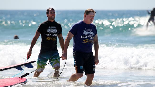 Joel Parkinson gives Wally Lewis and Paul "Fatty" Vautin a surfing lesson at Currumbin Alley. Joel Parkinson watches while Paul Vautin trudges out of the surf.Pic Glenn Hampson