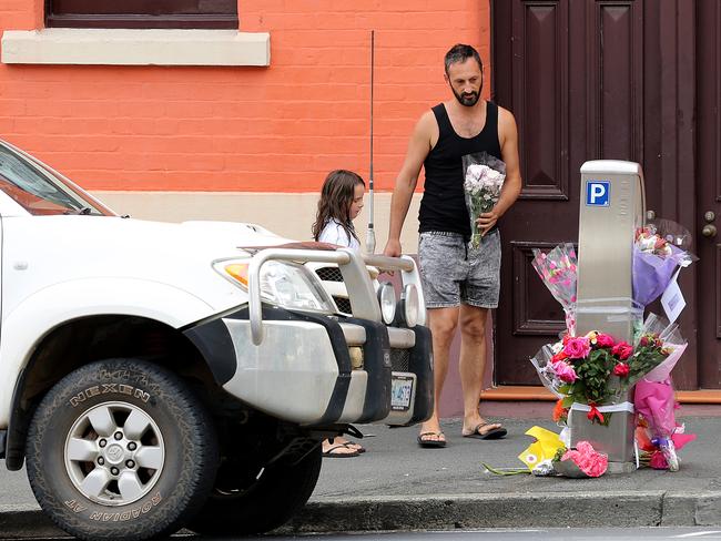 A man plces flowers at the memorial site in Davey St. Picture: SAM ROSEWARNE