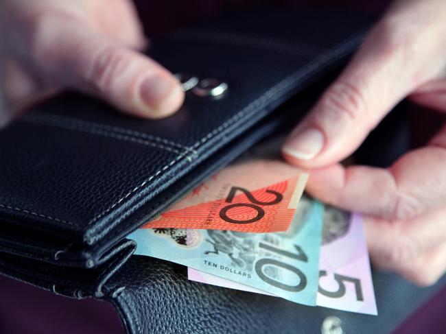 Adult woman female hand pulling out Australian money from a leather wallet. iStock