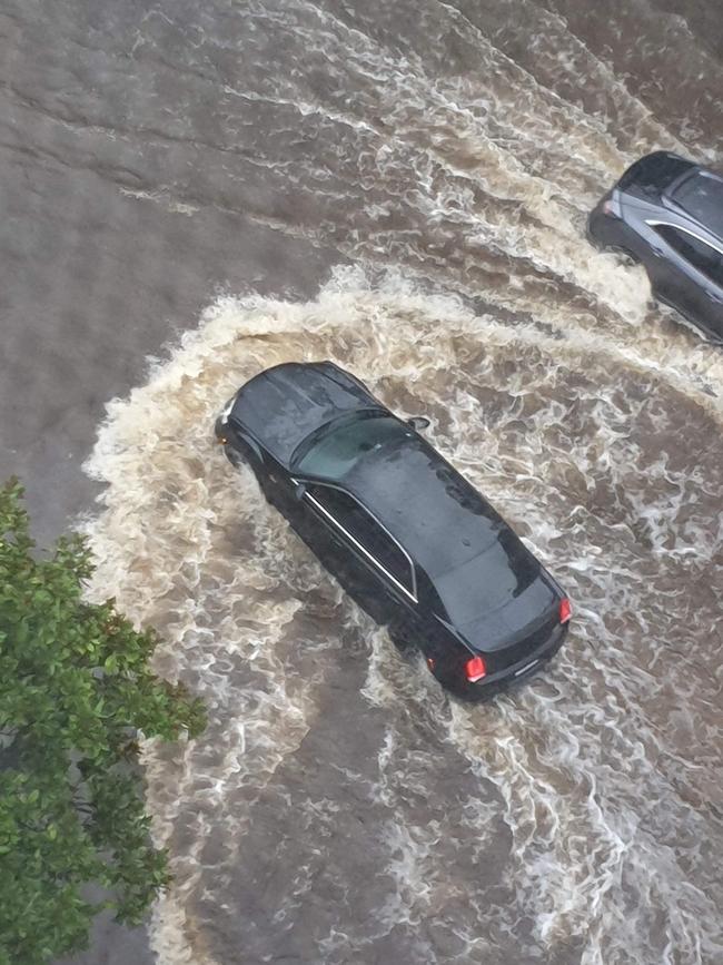 A car bound in floodwaters on Hill Rd in Wentworth Point. Picture: Lee Williams.