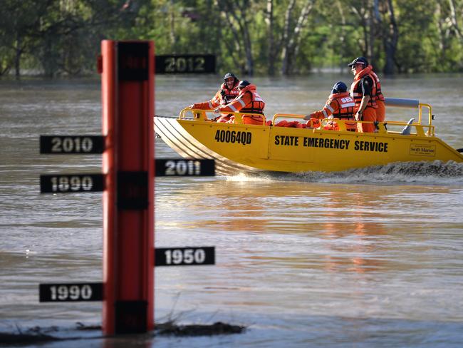 A State Emergency Service (SES) crew motors past a flood gauge on the swollen Balonne river in St George, south-western Queensland, Wednesday, February 26, 2020. The Balonne river is expected to break its banks and peak over 12 metres on Thursday, causing floods. (AAP Image/Dan Peled) NO ARCHIVING