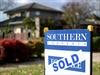 A sale sign is seen in front of a house in Canberra