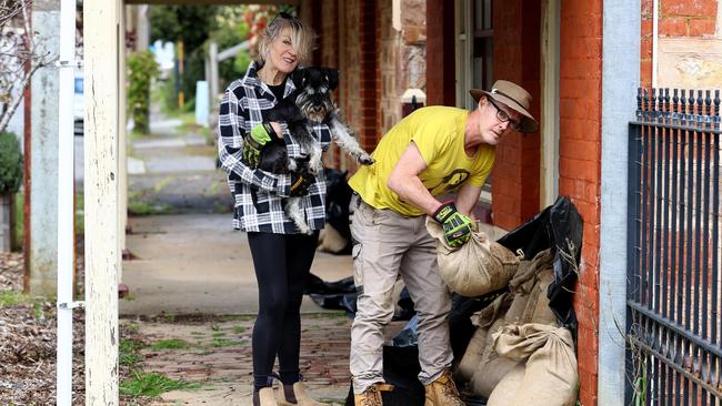 28th September 2022: Tracey Wadsley and Mark Badcock with their dog Ziggy sandbag their property on the main street of Echunga. Picture: Kelly Barnes