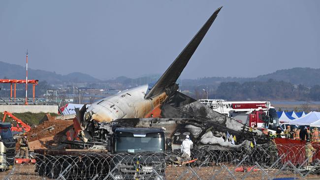 Firefighters and rescue personnel near the wreckage of the Jeju Air plane wreckage. Picture: AFP