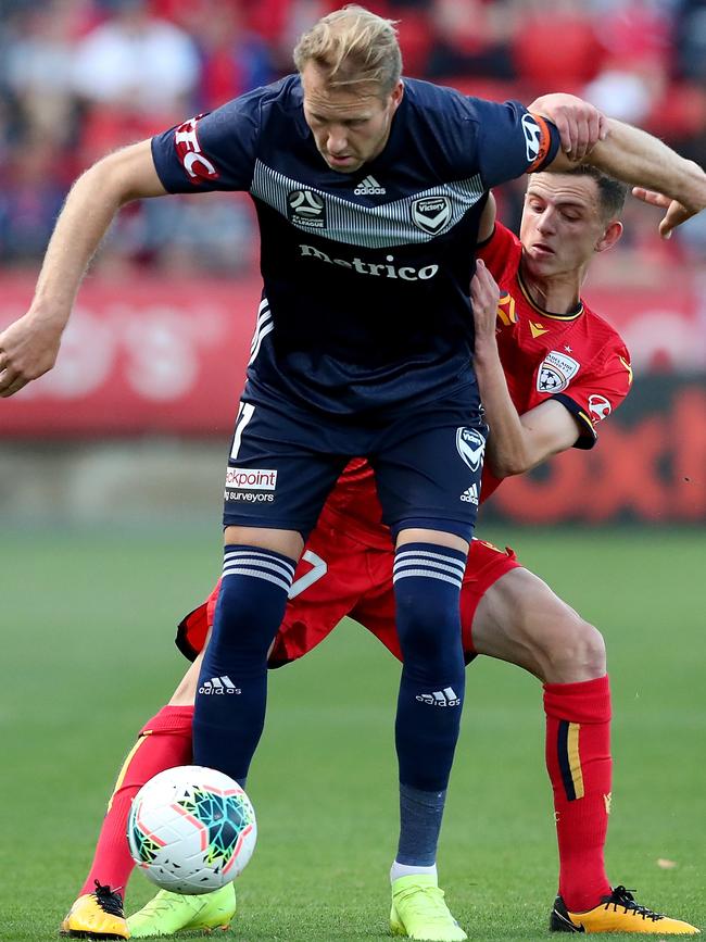 The Adelaide United young gun wins the ball from the Melbourne Victory captain. Picture: AAP Image/James Elsby