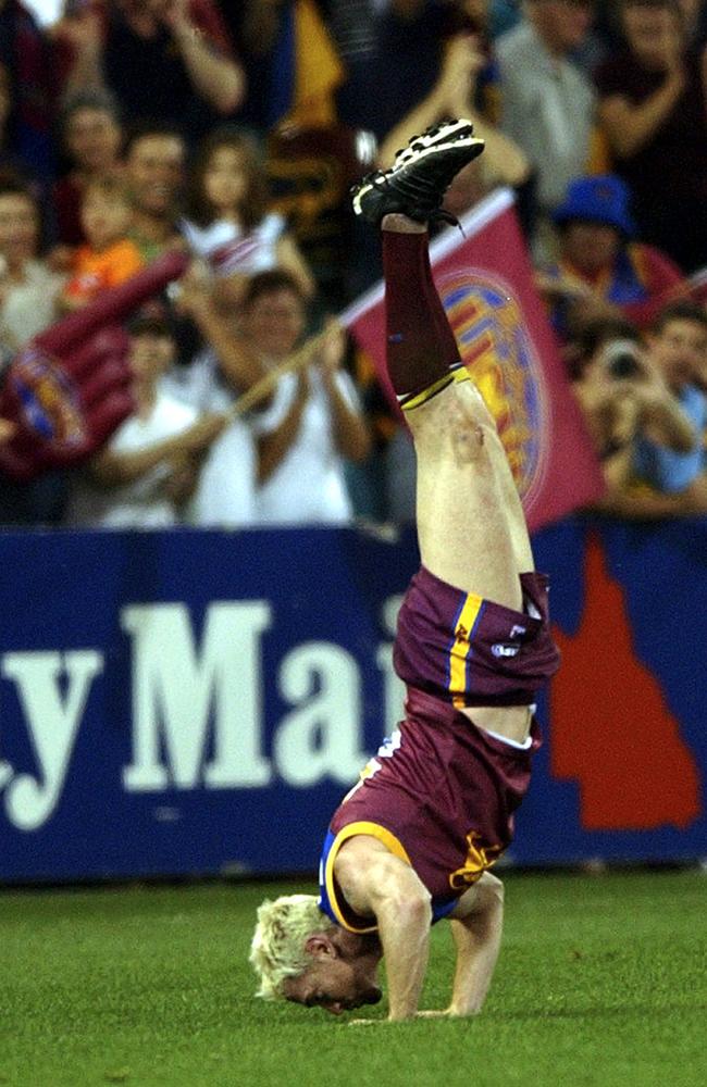 Brisbane's Jason Akermanis kisses the ground in a handstand after a semi-final win over Adelaide at the Gabba in Brisbane in 2003.